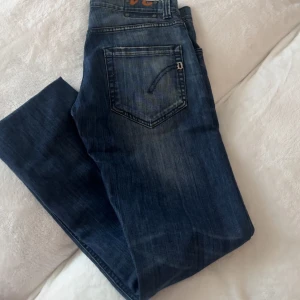  dondup - Snygga blå jeans från dondup modell med klassisk femficksdesign och diskret slitning på framsidan. Jeansen har raka ben och normal passform, perfekt för en avslappnad stil. Tillverkade i mjukt denimtyg för skön känsla hela dagen.knappt andvända gott som nya !