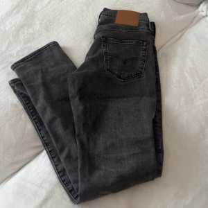 Levi's  jeans 512 - Snygga svarta jeans från Levi's med klassisk femficksdesign och rak passform. Jeansen har en mörk tvätt och är tillverkade i slitstarkt denim. Perfekta för dig som gillar en tidlös och clean look.29-32