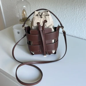 Brun axelväska - Säljer denna snygga och trendiga väska. Väskan är i ett mycket fint skicka och är  använd ett få tal gånger!