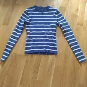 Blåvit randig tröja från 157 - Säljer en långärmad tröja från 157 i blått och vitt med horisontella ränder. Tröjan har rund hals och är i ett mjukt, stretchigt material som sitter snyggt på kroppen. Perfekt för dig som gillar klassisk stil med en modern touch.