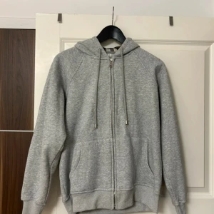 Grå hoodie dragkedja - Aldrig använd, helt ny! Storlek L men är lite liten, så den sitter som en M/S. Har tagit bort prislappen. Pris kan diskuteras. 