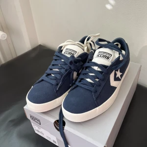 Converse Cons blå sneakers - Nya Converse pro vulc i marinblå mocka med vita detaljer i 41. Hör av dig om du har några funeringar. Skorna går knappt att få tag på längre och säljs för 2500kr på stockx. Priset är inte hugget i sten dock. 