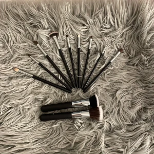 Set med sminkborstar och ögonskuggsborstar - Säljer ett komplett set med 11 smink- och ögonskuggsborstar med svarta handtag och silverfärgade detaljer. Borstarna har mjuka syntetiska strån i olika former för både ansikte och ögon, perfekt för att skapa snygga sminkningar och detaljerade looks. 💄Säljer dem för 450kr eller 50kr/st!