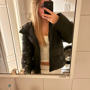 Svart pufferjacka från NAKD - Säljer en svart pufferjacka med quiltad design. Jackan har en loose passform och är långärmad, perfekt för kyliga dagar. Såå skön och toppen att köpa sin vinterjacka redan nu! 