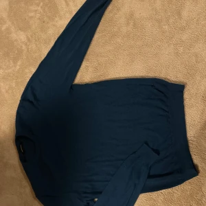 Mörkblå tröja från Matinique - En stilren mörkblå tröja från Matinique i storlek M. Tröjan har rund halsringning och långa ärmar, perfekt för lager-på-lager. Materialet känns mjukt och lätt, vilket gör den skön att bära under kyligare dagar. Passar som en 175!