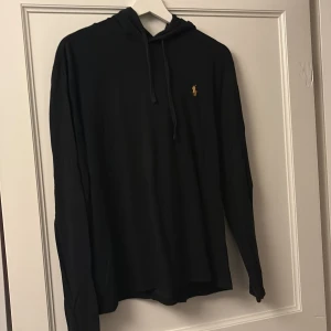 Svart hoodie från Ralph Lauren - Tunn svart hoodie i storlek S från Ralph Lauren, bra skick säljs billigt då den bara samlar damm just nu