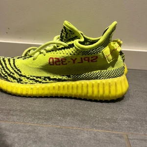 Adidas Yeezy Boost 350 V2 Semi Frozen Yellow - Säljer ett par Adidas Yeezy Boost 350 V2 i färgen Semi Frozen Yellow. Skorna är vi väldigt bra skick finns inga defekter på skorna förutom under skon där dom är lite skittiga men inget man ser när man använder skorna. Skicka till mig vid frågor skorna.