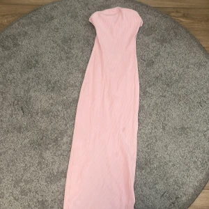 Ljusrosa ribbad långklänning FB Sister - Säljer en ljusrosa långklänning från FB Sister i storlek M. Klänningen är ribbad och har en slim passform med ärmlös design. Materialet är mjukt och stretchigt, perfekt för dig som gillar enkel och stilren look. Slits bak för extra rörelsefrihet.