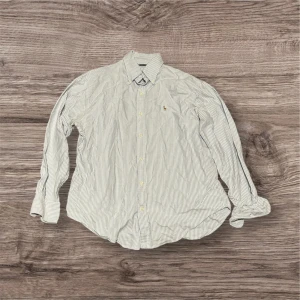 Randig skjorta från Ralph Lauren  - Klassisk skjorta från Ralph Lauren Sport i vitt och blått med tunna ränder. 