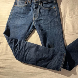 Levi's 501 CT mörkblå jeans - Klassiska Levi's 501 CT jeans i mörkblå denim med raka ben. Snygga kontrastsömmar och knappgylf. Perfekta för dig som vill ha ett par jeans som funkar till allt.