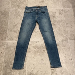 Blå slim jeans från Tiger of Sweden - Snygga blå jeans från Tiger of Sweden med klassisk design. Jeansen har en smal passform och är tillverkade i mjukt denimtyg. Perfekta för dig som gillar en stilren och modern look. Storlek 30.32 pris kan ändras vid köp!