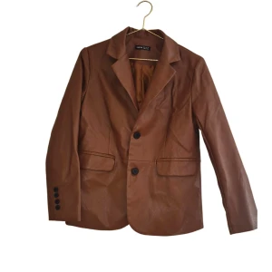 Brun skinnjacka/blazer  - Brun jacka/blazer/kavaj i pu läder/skinn/skinnimitation som är helt oanvänd.  Slutsåld & köpt för 600:- 