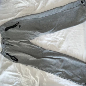 Grå mjukisbyxor från Nike med dragkedjor - Nike tech byxor använda i en säsong 