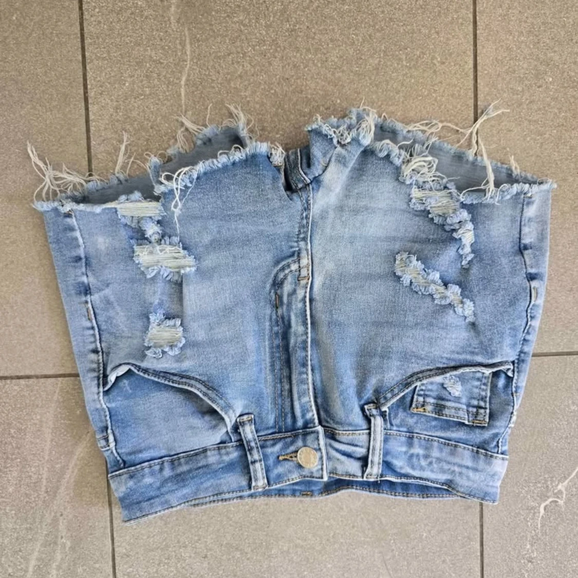 Ljusblå jeanskjol med slitningar