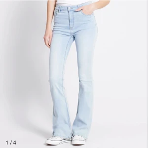 Ljusblå bootcut jeans med hög midja - Snygga ljusblå jeans med bootcut-modell och hög midja. Jeansen har klassisk femficksdesign, dragkedja och knapp framtill. Perfekta för dig som gillar en retroinspirerad look med utsvängda ben. Tillverkade i mjukt denimtyg.