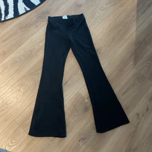 Svarta bootcut byxor från Gina Tricot - Svarta bootcut byxor från Gina Tricot i mjukt stretchigt material. Låg och utsvängda ben ger en snygg siluett. Perfekta för dig som gillar en trendig och bekväm look.💕