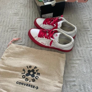 Converse Golf Le Fleur One Star Red - Säljer ett par Converse One Star Ox Golf Le Fleur i färgen vit och röd. Skorna har röda snören, röd sula och detaljer med Golf Le Fleur-logga på sidan. Tillverkade i skinn och kommer med allt OG, Dustbag, Låda och kvitto som bevisar äkthet, samt en gammal stockx tag som tyvärr inte funkar längre. Storlek 42, undersulen är lite sliten. Vid fler frågor eller funderingar tveka inte på att skriva!