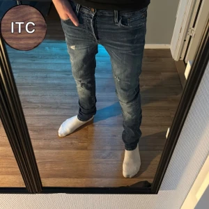 Jack & Jones Jeans  - Säljer ett par blå jeans från Jack & Jones med slitna detaljer och snygg tvätt. Storleken är 28/32 och sitter som slim fit.