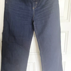 Mörkblå jeans från Zara, stl 40 - Snygga mörkblå jeans från Zara i klassisk modell med raka ben och kontrastsömmar. Jeansen har normal passform och är tillverkade i ett slitstarkt bomullsjeanstyg. Perfekta för dig som gillar stilrena och tidlösa jeans.
