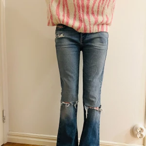 Diesel jeans bootcut - Snygga blå jeans från Diesel med bootcut passform och slitna detaljer vid knäna. Klassisk femficksmodell med låg midja och coola slitningar både fram och bak. Jeansen är i denim och har en autentisk tvättad look med råa kanter vid knäna. obs se defekt på sista bilden. 100% ull❤️❤️