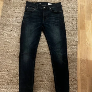 Mörkblå skinny jeans Tiger of Sweden - Mörkblå jeans från Tiger of Sweden med klassisk femficksdesign och snygga kontrastsömmar. Modellen är skinny fit med smala ben och normal midja. Jeansen är tillverkade i stretchig denim för en bekväm passform och har läderpatch med logga bak. 31-30
