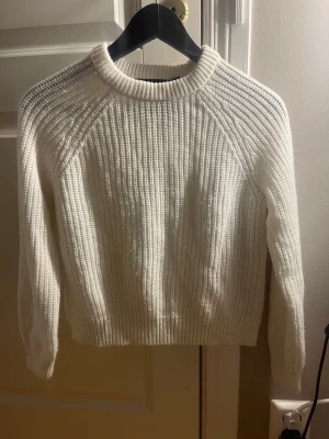 Vit stickad tröja från Vero Moda - Säljer en vit stickad tröja från Vero Moda i storlek S men som storlek XS. Tröjan har en klassisk rund halsringning, ribbade muddar och lång ärm. Perfekt för lager på lager under kyliga dagar och enkel att matcha till olika outfits.