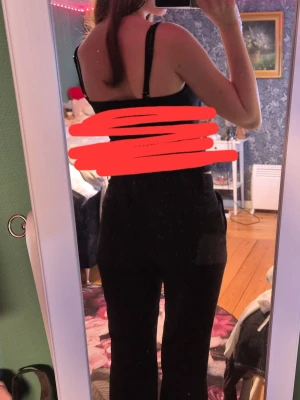 Svarta bootcut kostymbyxor - Säljer ett par svarta kostymbyxor med bootcut passform och medel/låg midja. Storlek 170 men är som storlek S. De har en enkel och clean look som passar till det mesta. Materialet känns mjukt, vilket gör dem riktigt sköna att ha på sig. Perfekta om du gillar en klassisk men ändå trendig stil.