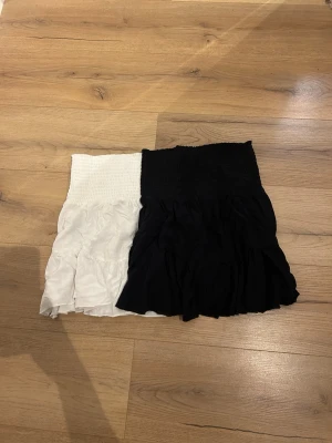 Två volangkjolar i vitt och svart - En svart och en vit kjol. lappen är bort klippt på båda så vet inte var de är ifrån, Mycket bra skick.  Storlek XS😊