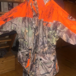 Jakt ställ för barn - Bilderna visar ett jaktställ från Euro-Hunt med camouflage- och orange detaljer syns på bilderna.   liten i storleken för att vara 150 jacka och byxor hör ihop knappt använd!