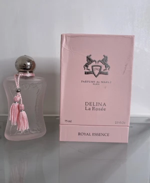 Delina La Rosée EdP 75ml - Delina La Rosée från Parfums de Marly är en elegant parfym i en lyxig rosa flaska. Volymen är 75 ml och den ingår i Royal Essence-serien. Perfekt för dig som vill ha en exklusiv och trendig doft i samlingen.