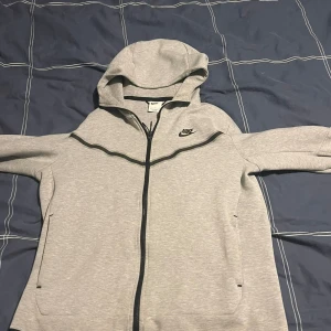Nike tech grå - Säljer nu min Nike tech!  Tagit väl hand om den, säljer nu för att jag växt ur den!  Mycket fint skick och inga fläckar eller sönder nånstans!  Storlek M