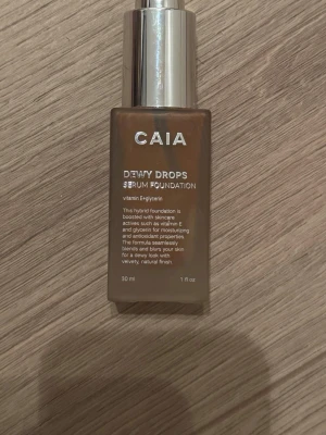 CAIA Dewy Drops Serum Foundation - Säljer en CAIA Dewy Drops Serum Foundation med pump. Som inte matcha min ton och är använd bara en gång. Färgen är medium till mörk beige och flaskan rymmer 30 ml. Innehåller vitamin E och glycerin för återfuktning och lyster. Ger en naturlig, daggig finish och kommer i en stilren glasflaska med silverfärgad pump.