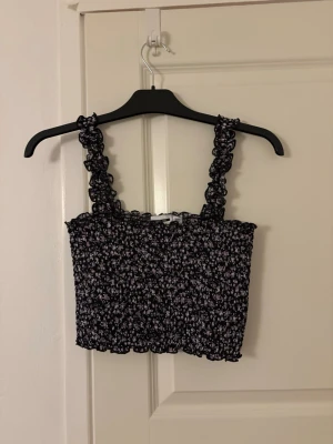 Somrig topp - Blommig topp som är perfekt till sommaren🌸 toppen är croppad och har ett väldigt stretchigt material. Skicket är mycket bra, toppen är knappt använd!