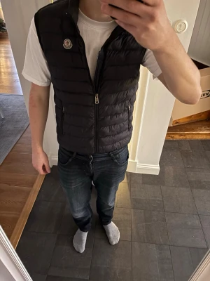 Svart dunväst från Moncler - Hej 👋 säljer denna fetta väst i storlek 1 skulle säga att den sitter som M inga defekter men har använts en del du vet varför priset är så lågt