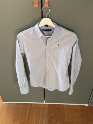 Ljusblå skjorta från Ralph Lauren - Snygg ljusblå skjorta från Ralph Lauren. Den är knappt använd och därav i bra skick. Hör av dig vid frågor och funderingar.Priset är ej hugget i sten. 