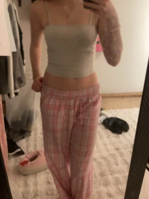 Ljusgrå croppad linnetopp H&M Divided - Säljer en enkel och stilren ljusgrå croppad linnetopp från H&M Divided. Toppen har tunna axelband och ärmlös design, perfekt för varma dagar eller som layering-piece. Mjuk och stretchig i materialet för en bekväm passform.