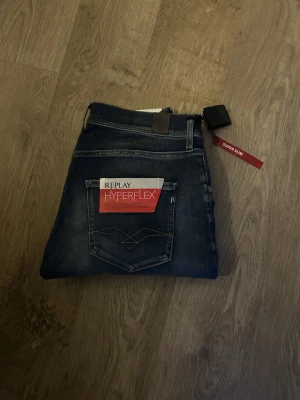 Replay Hyperflex Super Slim Jeans - Säljer ett par mörkblå Replay Hyperflex jeans med super slim passform. Midja 36 cm / Längd 109 cm. Jag är 177 cm på den sista bilden.