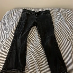 Svarta bootcut jeans från lager 157 - Säljer ett par svarta bootcut jeans från lager 157  med klassisk femficksdesign och hög midja. Jeansen har en snygg tvättad look och är tillverkade i mjukt jeansmaterial. Perfekta för dig som vill ha en retrovibe i garderoben.