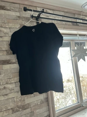 Svart basic t-shirt från Cubus - En svart basic t-shirt från Cubus i storlek S. Klassisk rund halsringning och korta ärmar. Tillverkad i mjuk bomull som är skön att bära. Perfekt till jeans eller shorts för en clean och enkel look.