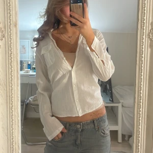 Vit långärmad linneskjorta - Säljer en vit skjorta i linne med lång ärm och klassisk krage. Skjortan har knappar framtill och  bröstficka med lock. Materialet är tunt och luftigt, perfekt för varmare dagar. Passformen är normal och skjortan har en avslappnad vibe.💕