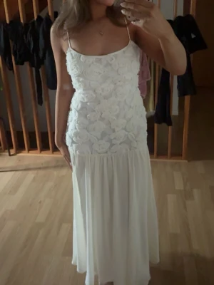 Balklänning  - Superfin vit långklänning med tunna axelband och 3D-blommor upptill. Superfin och söt kläning använd en gång🫶