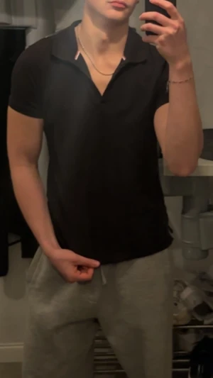 Svart henley från Berkeley - Svart henley från Berkeley med korta ärmar och krage med diskreta rödvita detaljer. Skjortan har en clean look och är gjord i mjuk bomull som känns skön mot huden. Perfekt för dig som gillar stilrena plagg med lite edge.