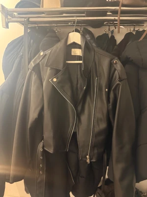 Svart skinnjacka från NLY Trend - Snygg svart skinnjacka från NLY Trend. Knappt använd. Strl 36