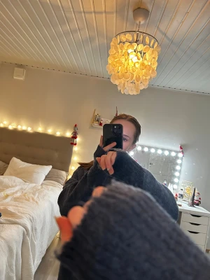 Mörkblå stickad tröja med lång ärm - Säljer en supermysig mörkgrå stickad tröja med lång ärm och rund hals. Tröjan har en loose passform och är perfekt för dig som gillar oversized stil. Materialet är mjukt och fluffigt, vilket gör den extra skön att bära under kyliga dagar. 