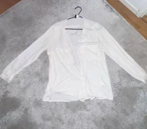 Vit långärmad skjorta/blus med fickor - Snygg vit skjorta med långa ärmar och två bröstfickor. Skjortan har klassisk krage och knappar framtill. Materialet känns lätt och luftigt. Storlek 38 💗