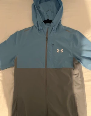 Blå och grå vindjacka från Under Armour - Fast pris 