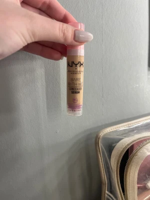 NYX Bare With Me Concealer Serum - NYX Bare With Me Concealer Serum i färgen Vanilla. Kommer i en smidig tub med rosa pump och transparent lock. Serumformulan är lätt och krämig, perfekt för att täcka mörka ringar och ojämnheter. Innehåller tremella mushroom för extra fukt. Volym: 9,6 ml. Färgen VANILLA använd väldigt lite men fungerade inte på mig
