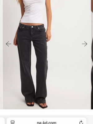 Svarta wide jeans från NA-KD - Snygga svarta jeans från NA-KD med låg midja och breda ben. Jeansen har klassisk femficksdesign, raka sömmar och en avslappnad passform. Perfekta för en trendig och chill look.