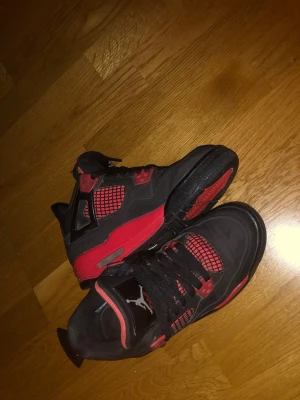 Nike Air Jordan 4 svart/röd sneakers -  Helt nya Air Jordan 4 Red Thunder i storlek 35/36, komplett med originalförpackning! Passa på att fynda ett par coola  fräscha skor