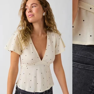 Vit prickig blus från Gina  - Säljer en söt vit blus med svarta prickar från Gina Blusen har korta ärmar och en v-ringad design med knytband i midjan ! Slutsåld på hemsidan. Kapper med storlek finns one kvar men det var nog xs eller s! Använd 1 gång. 